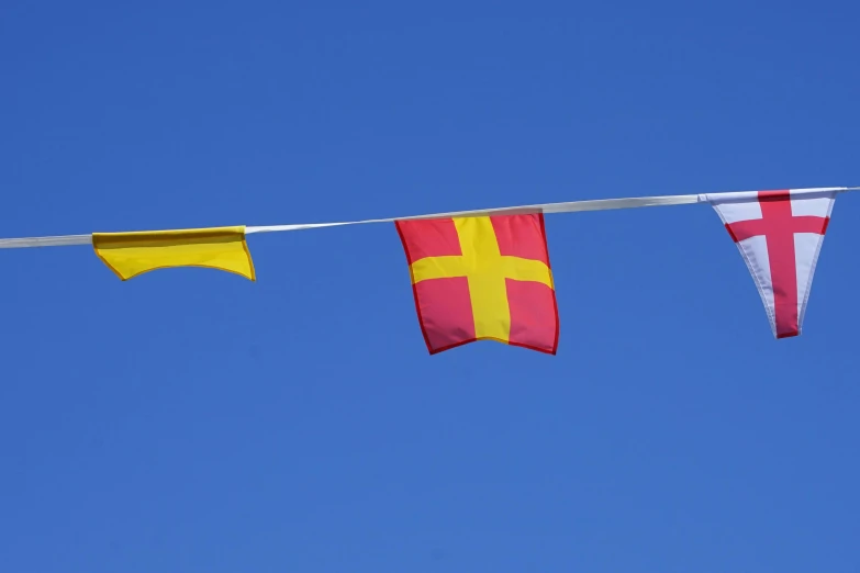 three flags that are hanging on a clothes line