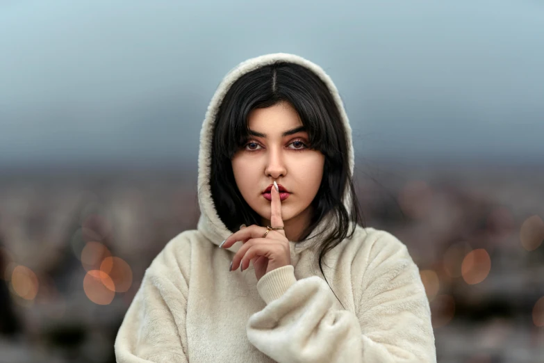 an asian woman is smoking in front of a blurry background