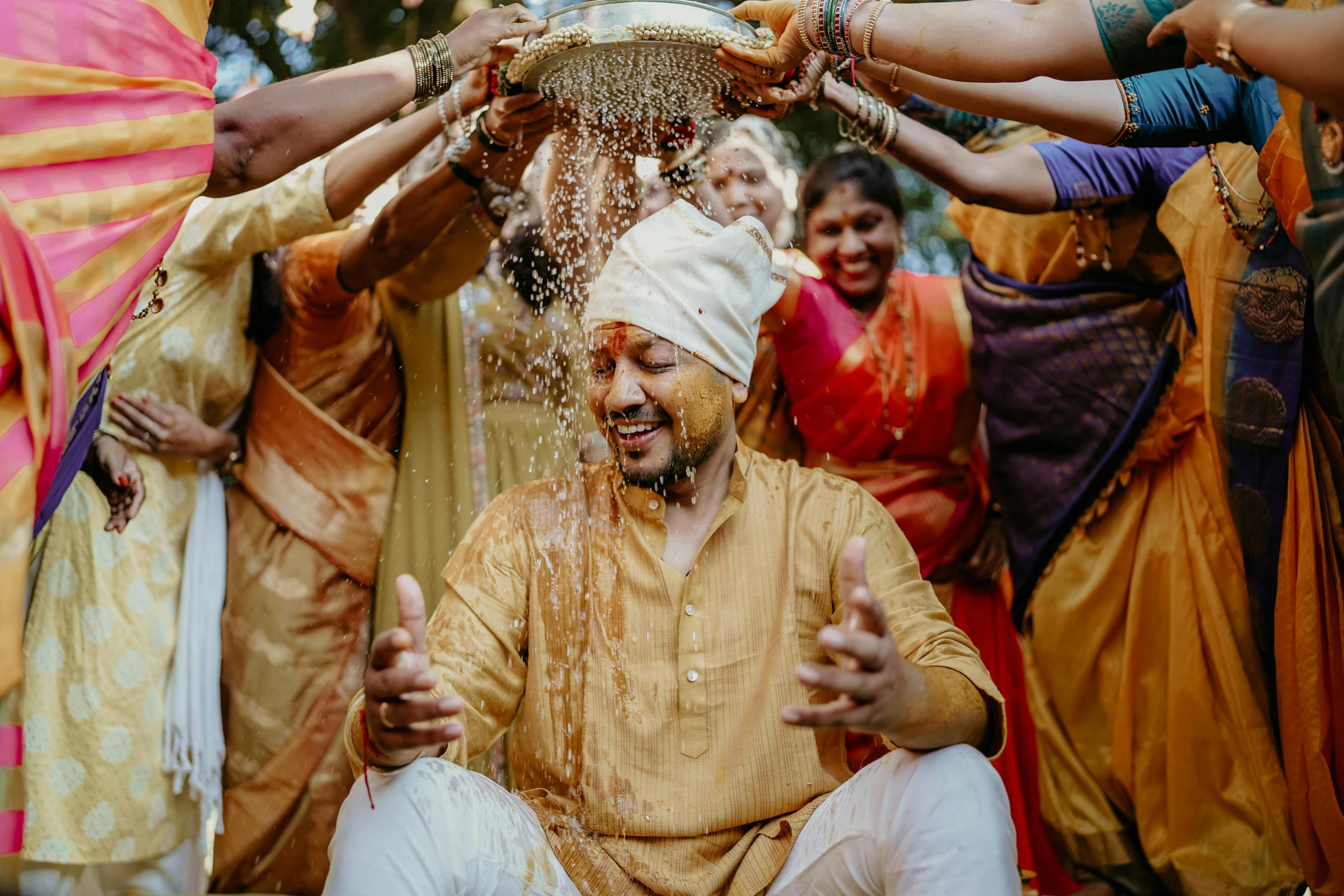 a group of men giving people water from a pot