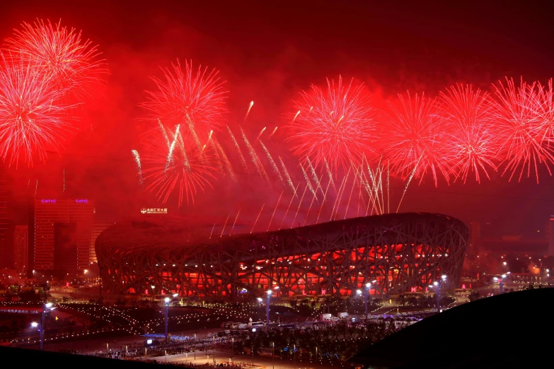 fireworks are lit up over a stadium as a building is being demolished