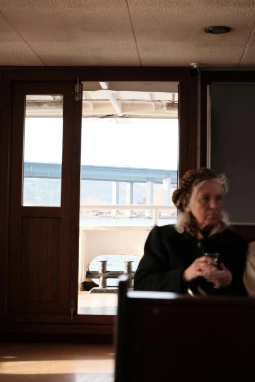 an older lady sitting in a room on a boat