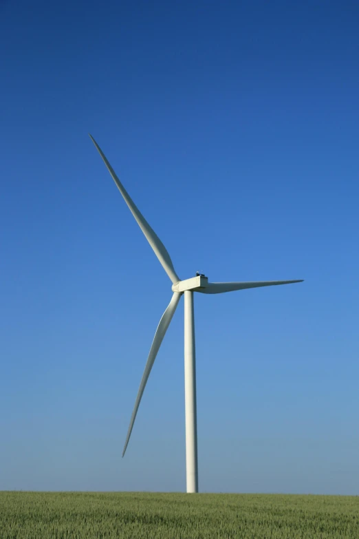 a wind turbine sits in a grass field