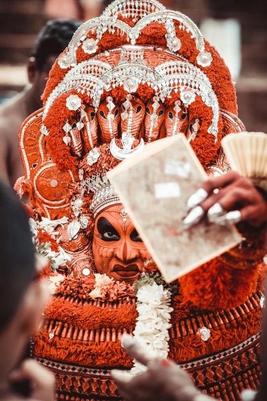 a woman dressed in an orange costume with elaborate decorations