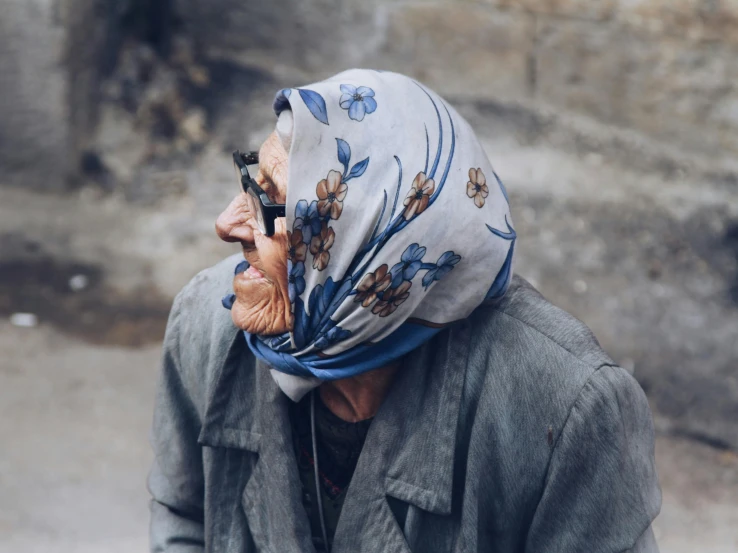 a woman is wearing a headscarf while she holds a phone