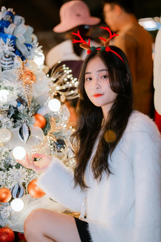 a woman sitting on the ground with red antlers