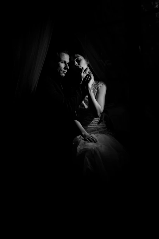 a couple in the dark with a black background