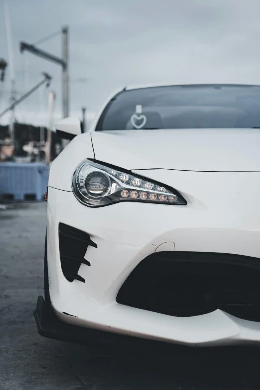 the front of a white sports car with the hood up