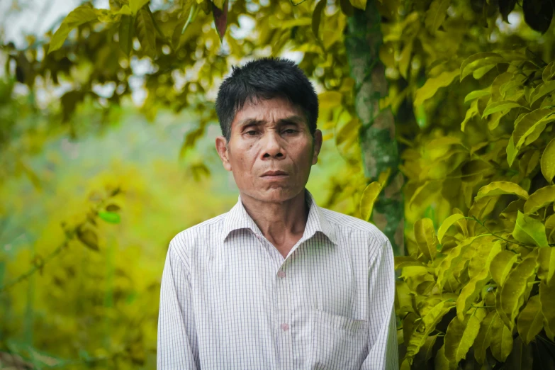 a man posing for the camera under trees