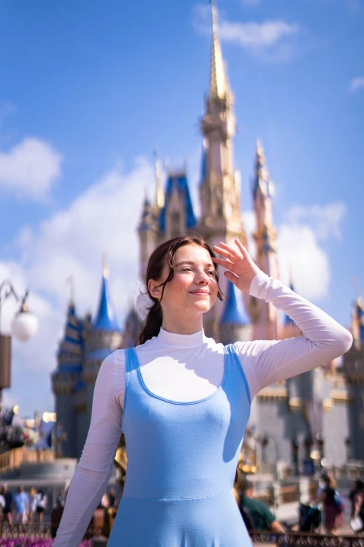 the woman in a blue dress is looking at the castle