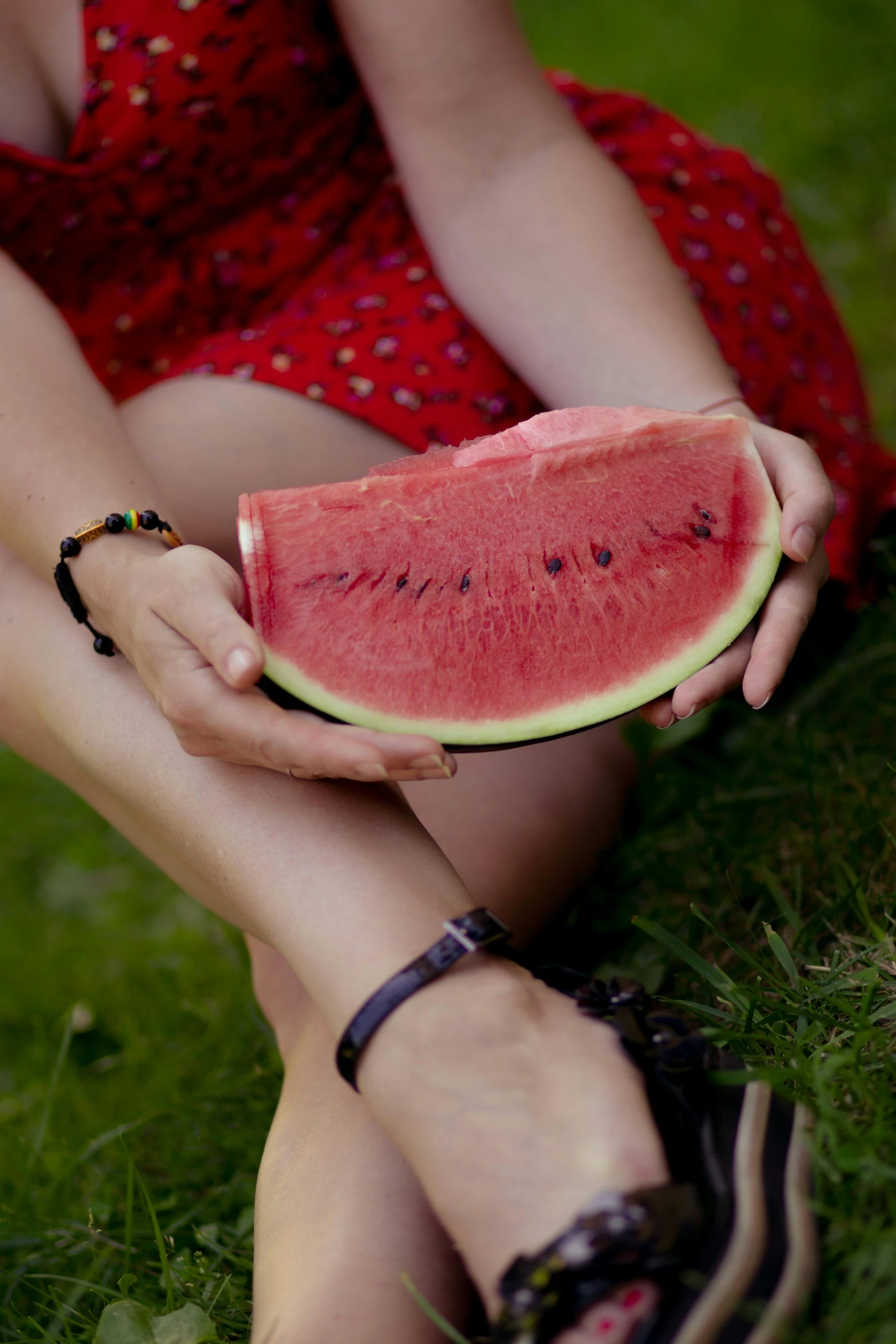 a woman in a red dress holding a watermelon slice