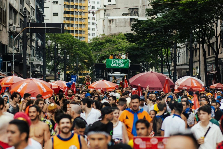 many people are walking down the street with red umbrellas