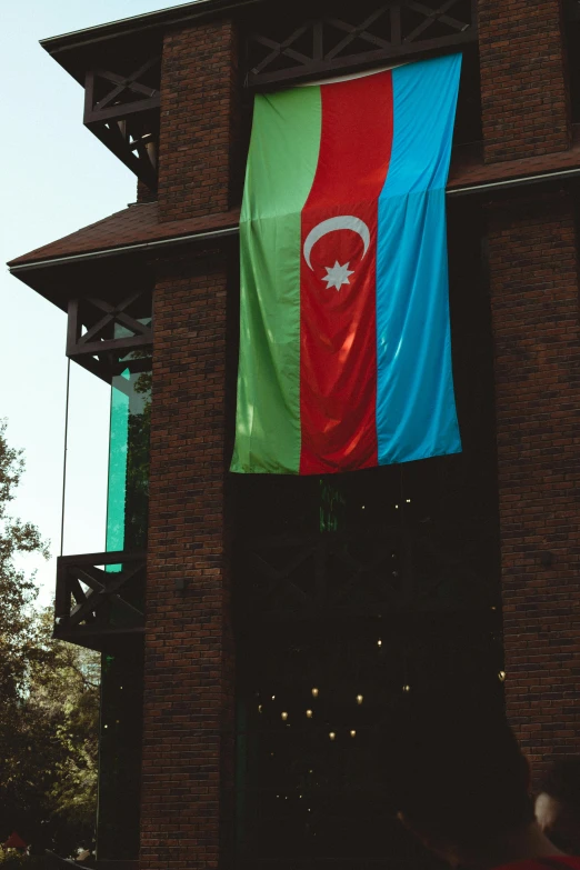 a large flag hanging from the side of a building