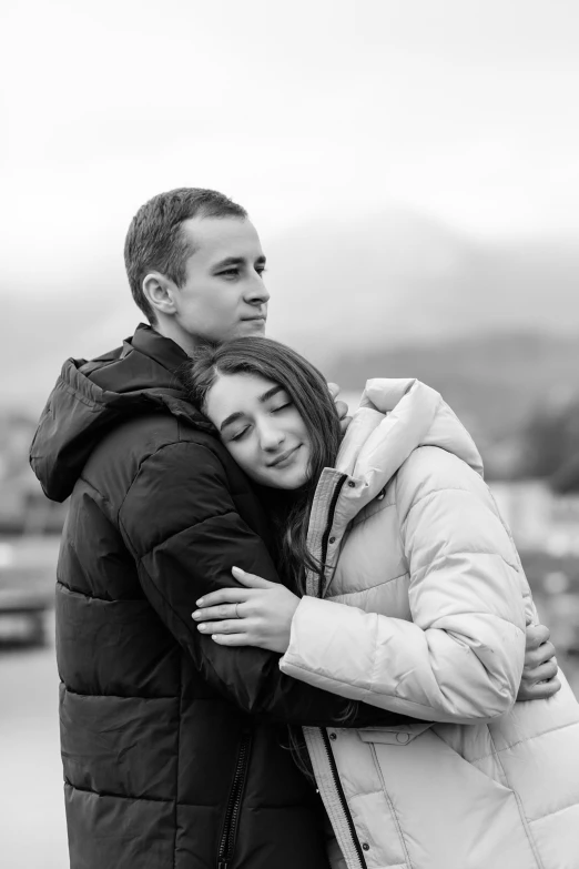 black and white pograph of couple hugging under an umbrella