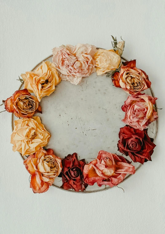 a circular metal tray with flowers arranged inside of it