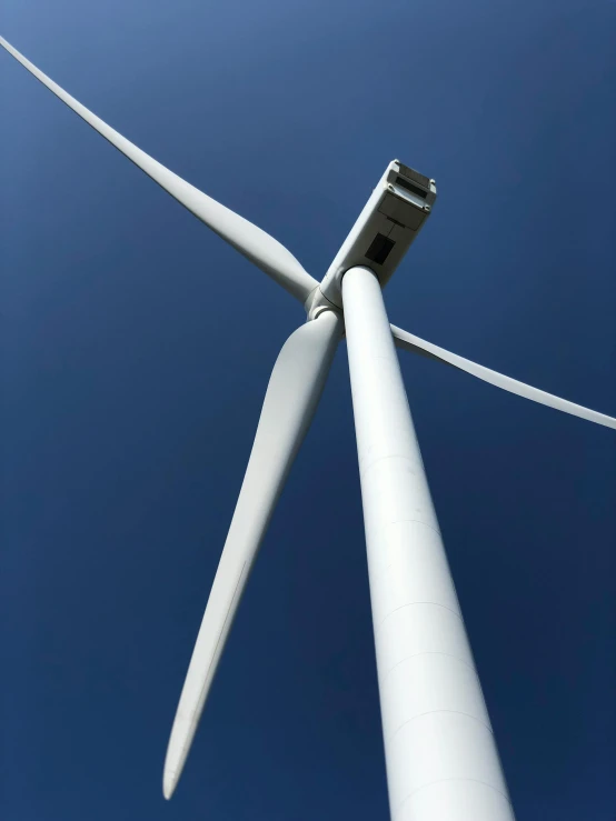 a wind turbine with a small tower in the background