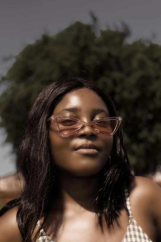 a woman wearing sunglasses poses for the camera