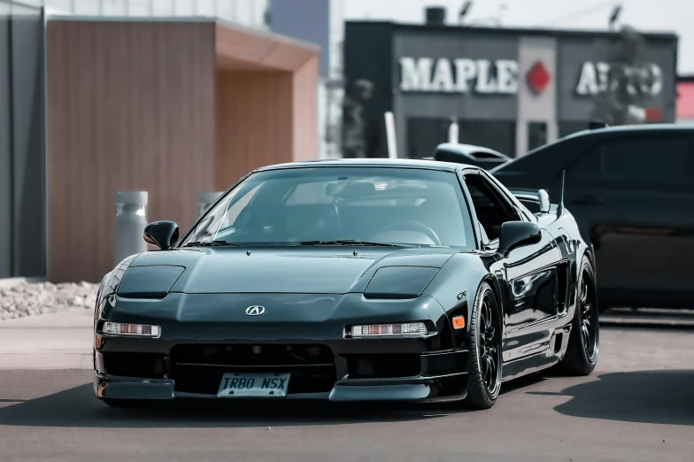 the black toyota mr2 is parked near some other cars