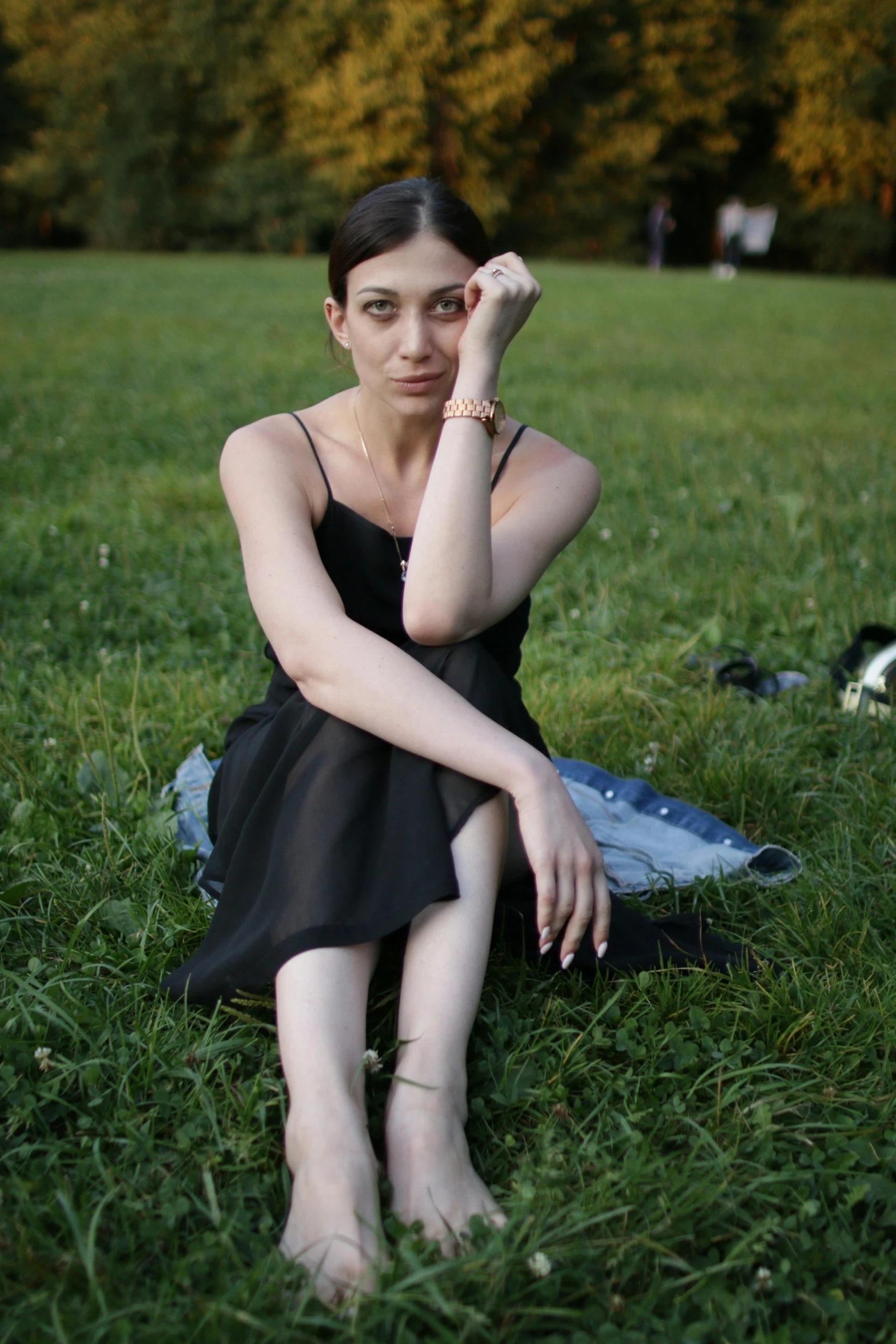 a woman sitting on the ground with her hand on her head