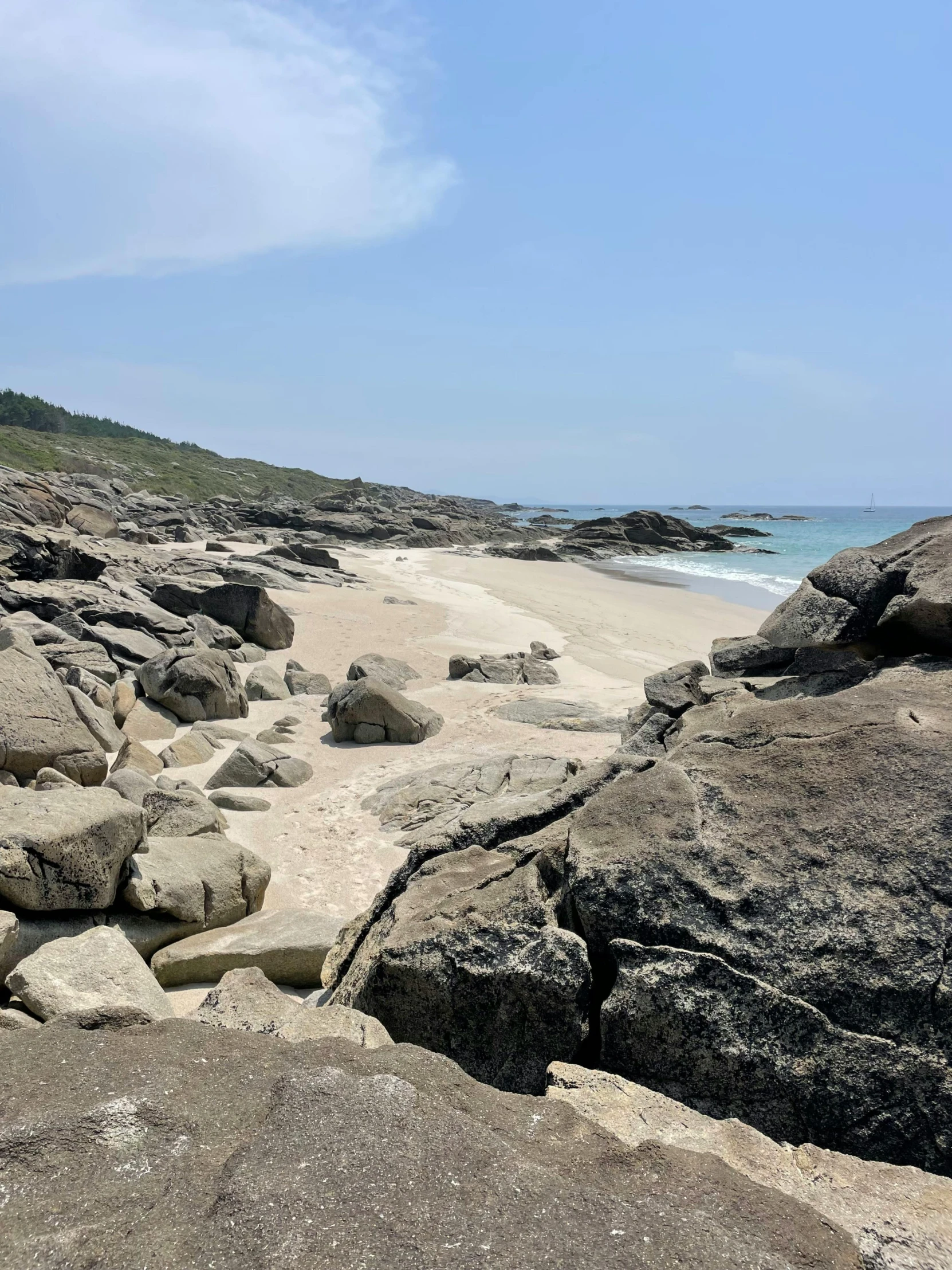 a large rocky shore area with water and a sandy beach