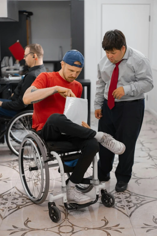 two young men in wheelchairs look at soing