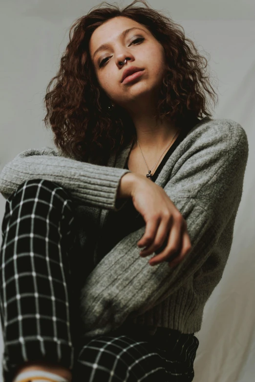 a young woman sits in the middle of a studio shoot