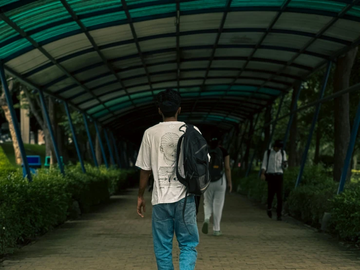 a man is walking down the walkway carrying a backpack