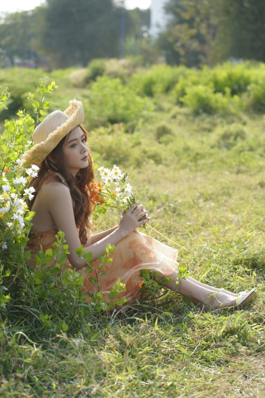 the woman is sitting in a field of flowers