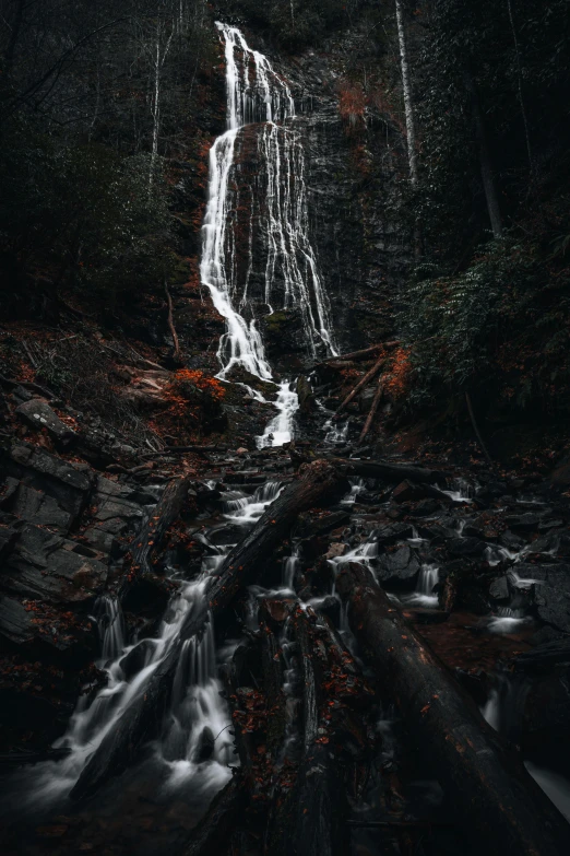 a waterfall is falling over rocks in the forest