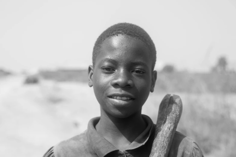 a  holding a stick while standing in the sand