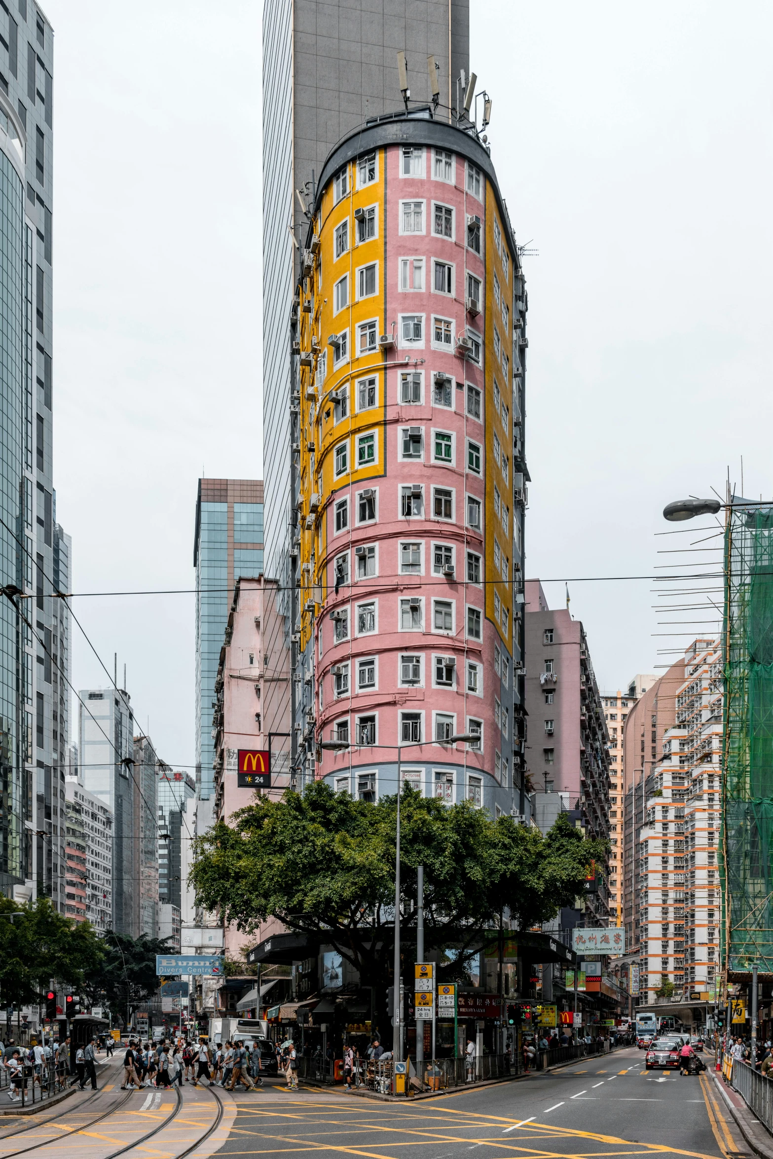 a tall red building towering over a street with lots of traffic