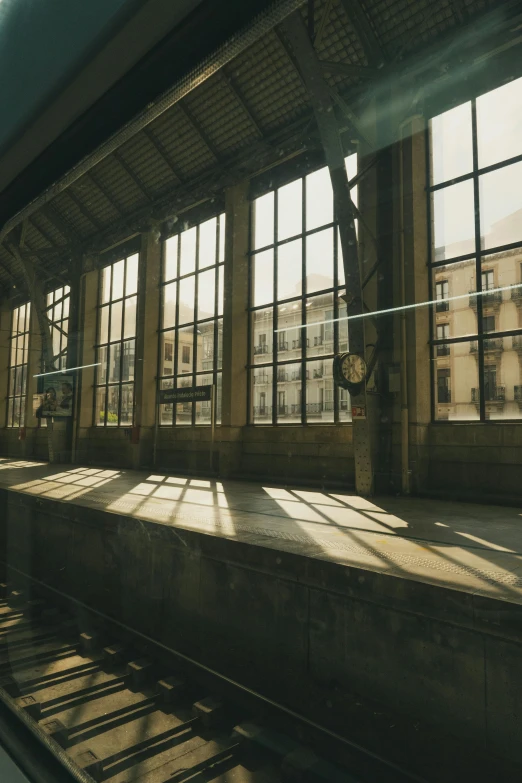 a train station with lots of windows and a long rail
