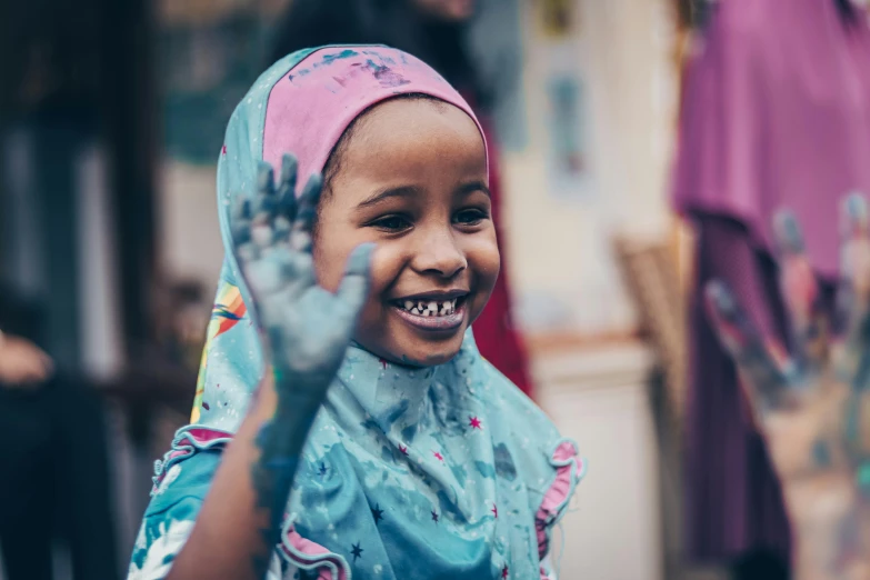 a smiling girl covered in mud standing in the doorway