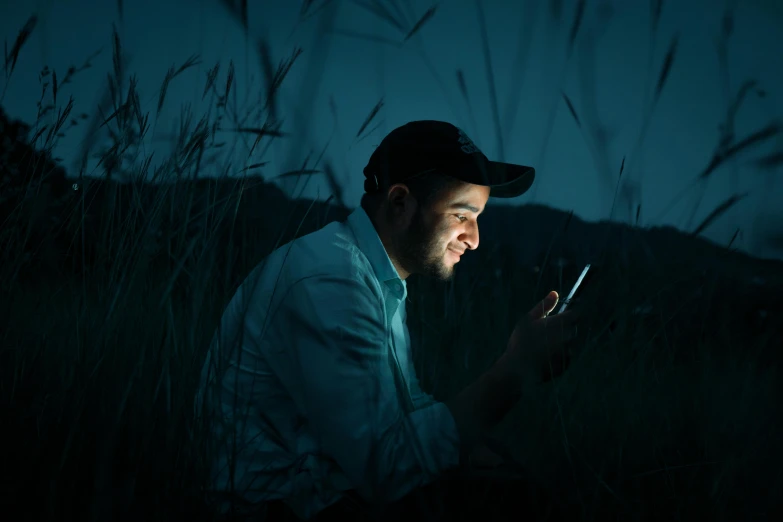 a man is using a phone in a dark area