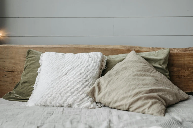 pillows sitting on top of a bed with a wall behind them