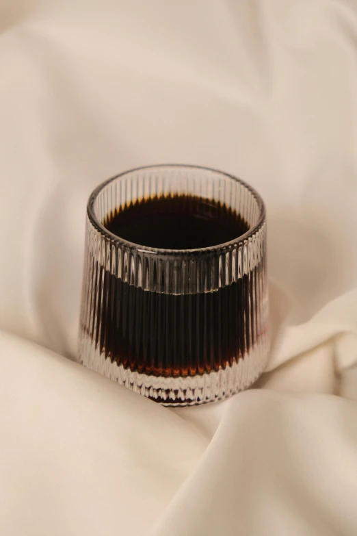 an empty cup sitting on top of a white surface