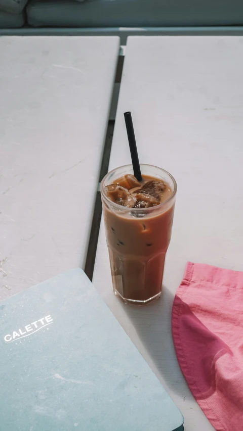 a pink napkin on a table with coffee and a book