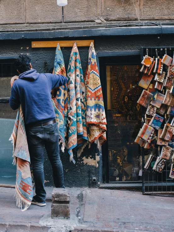 a man looks into an old shop with cloths on display