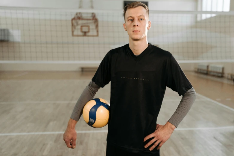a man in black holding a yellow and blue ball