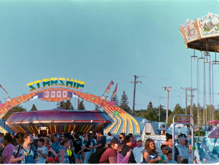 the carnival is filled with people standing around it