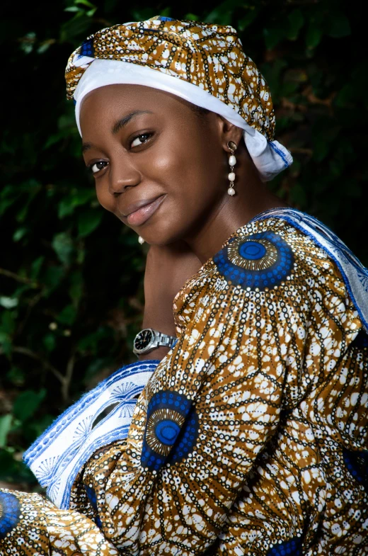 the woman is smiling and wearing a dress with a decorative pattern