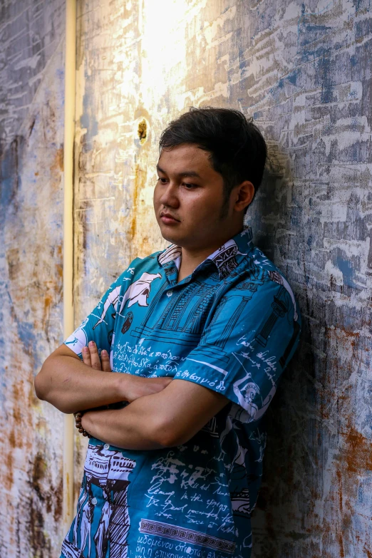 man leaning against a building with his arms crossed