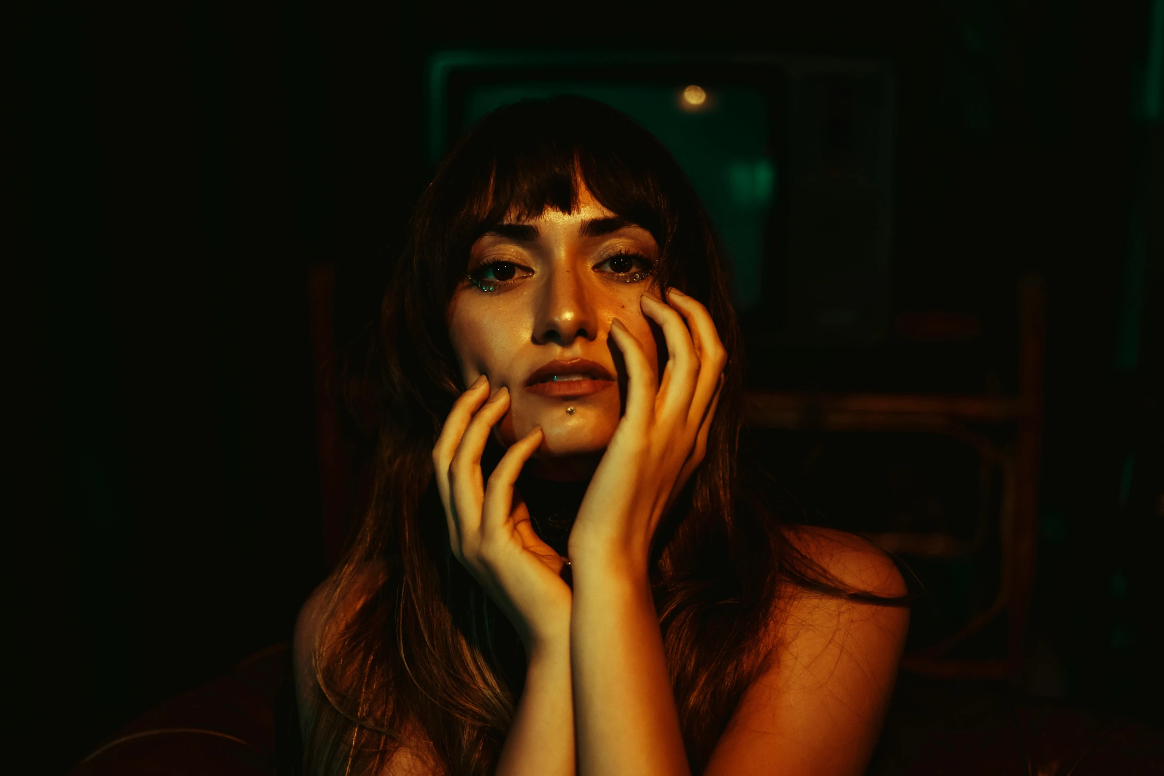 woman sitting alone holding hands up to her face