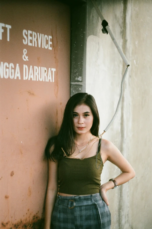 a girl standing next to a wall leaning on it