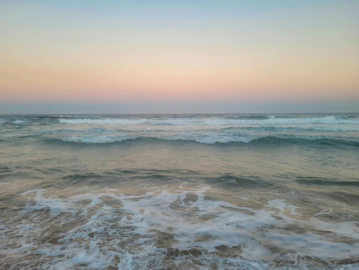 the beach has waves coming in and out on it