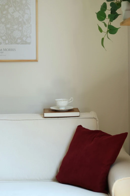 a picture of a white couch with a red pillow