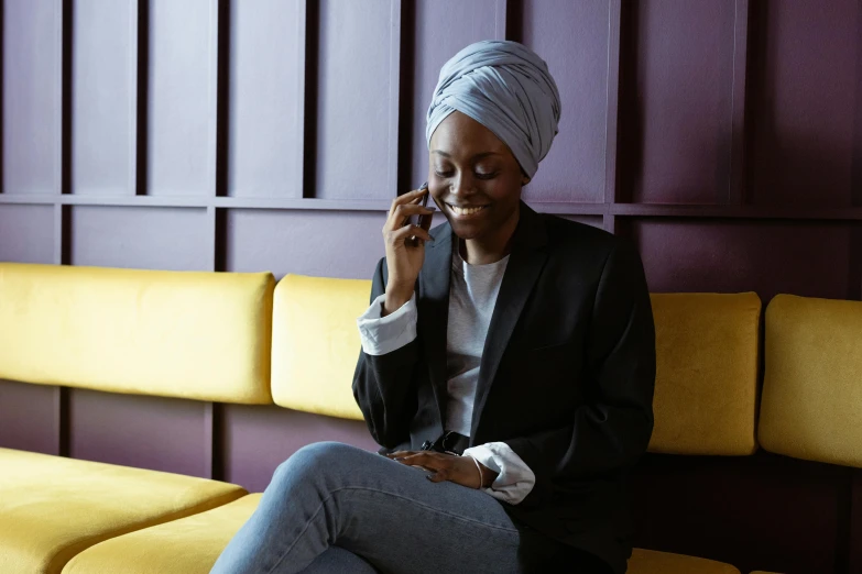 an old woman talking on the phone in front of a couch