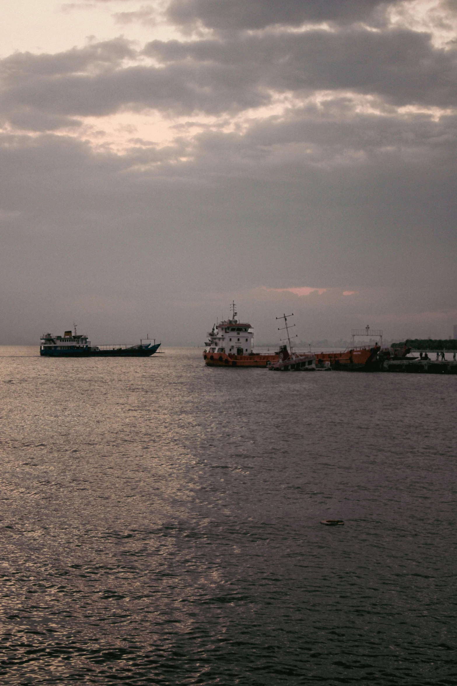 two ships at anchor on the water during low tide