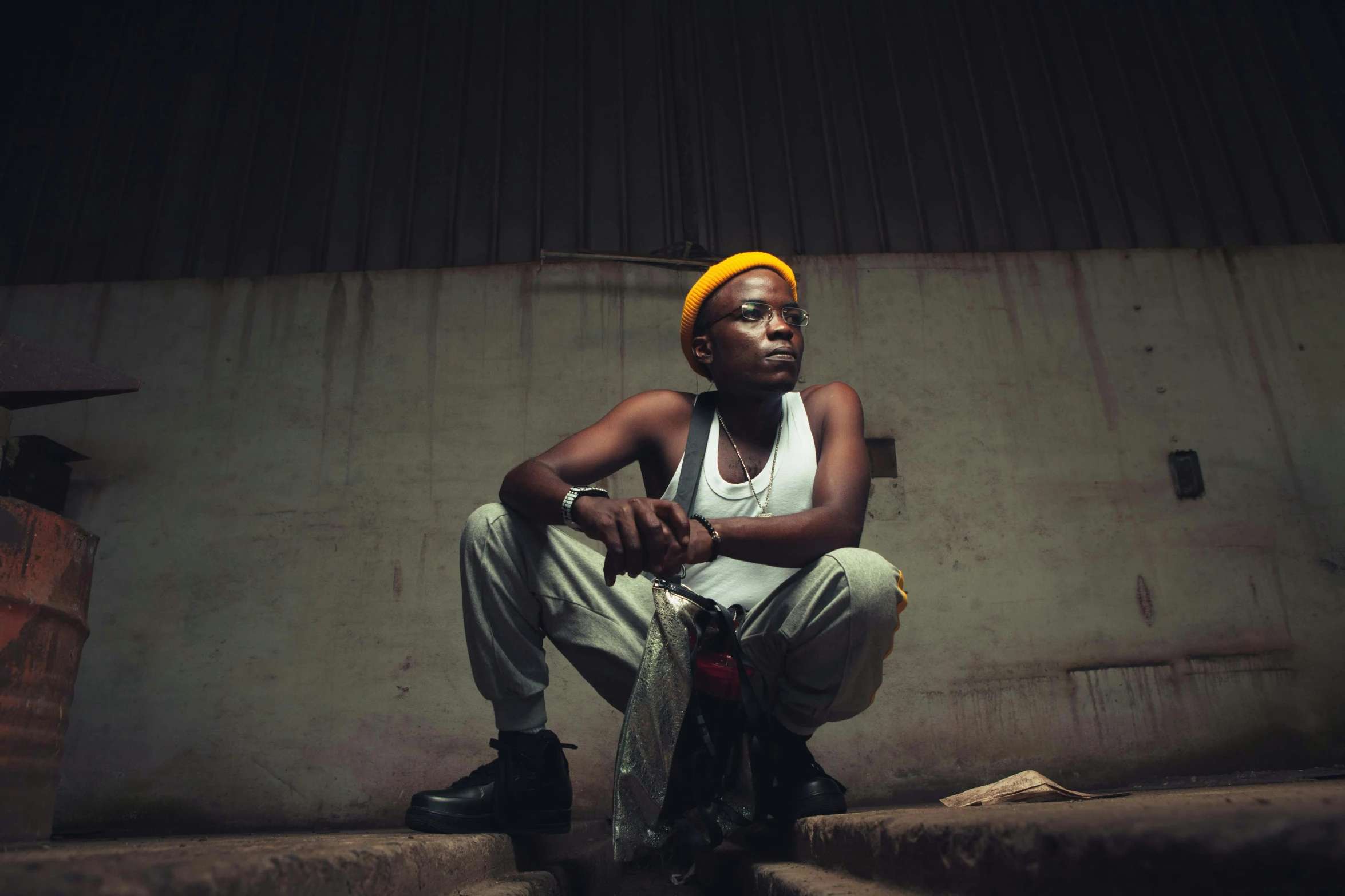 a man with a yellow turban sits on stairs in front of a wall