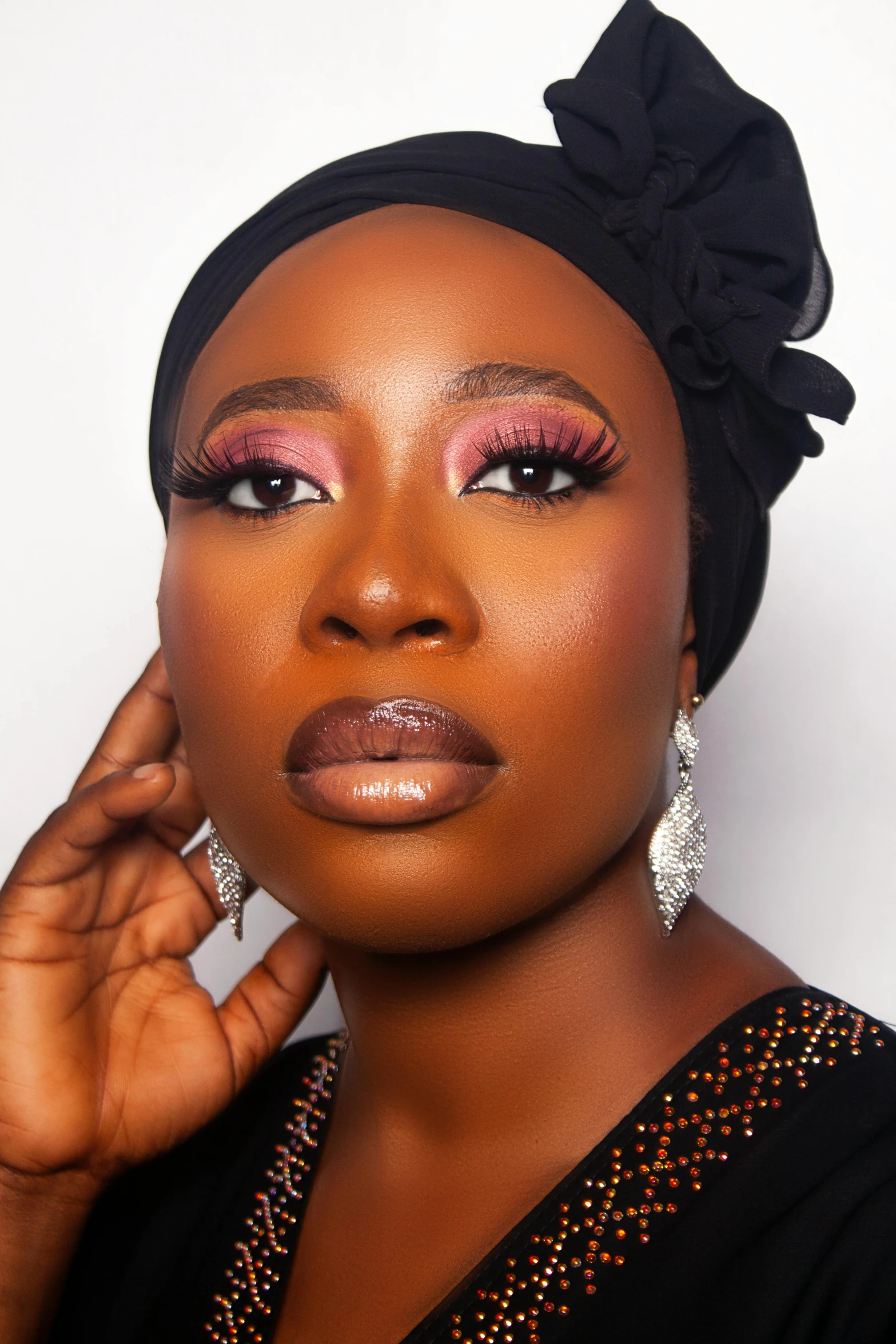 a black woman in a top hat and earrings