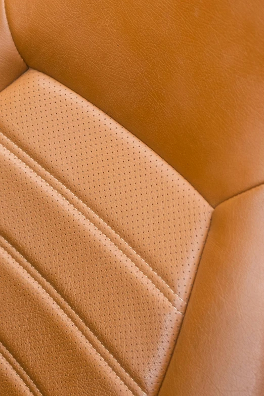 an upholstered, leather seat sits close to a wood panel